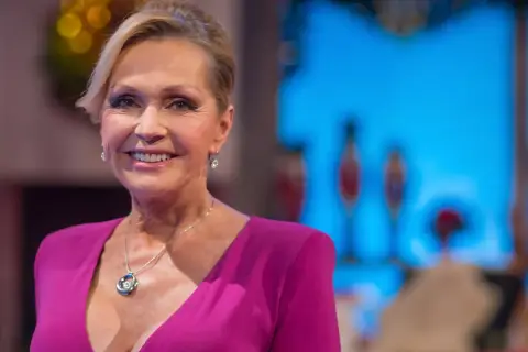 Uśmiechnięta Helena Vondráčková w fuksjowej sukni z naszyjnikiem.