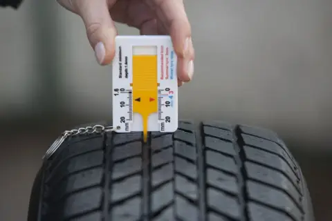 Sprawdzam, ile mm bieżnika mają nowe opony zimowe. Miernik wskazuje ponad 4 mm, co jest idealne.