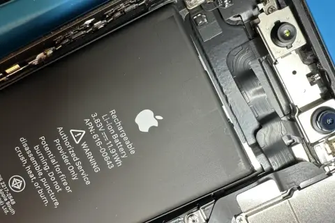 Wymiana baterii w iPhone 11. Widoczna bateria Li-ion z oznaczeniami i ostrzeżeniami.