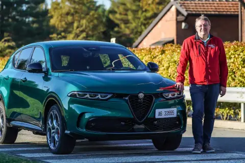 Ein Mann steht neben einem grünen Alfa Romeo Tonale, einem Alfa Romeo Plug-in Hybrid.