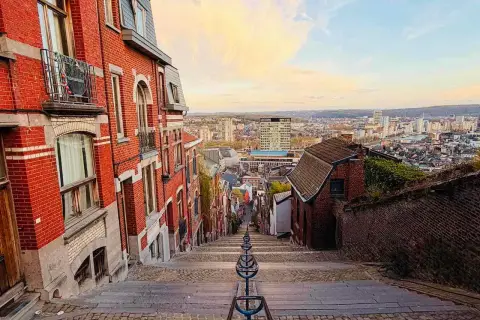 Treppen hinunter in eine Stadt in Belgien. Erkunden Sie die charmanten Gassen und genießen Sie die Aussicht – so kann man in Belgien machen!