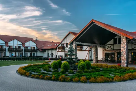 Hotel Mikołajki Leisure & Spa: piękne budynki z czerwonymi dachami, zadbany ogród i podjazd. Wiele pozytywnych hotel mikołajki leisure & spa opinie.