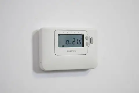 Termostato de la calefacción Equation, mostrando 21.5 grados y el día 10.