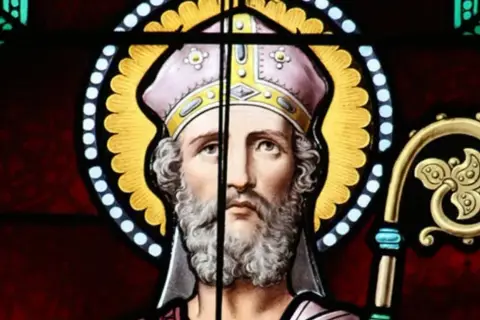 Witraż przedstawia świętego biskupa z brodą i mitrą, trzymającego pastorał. Obraz ten może przypominać o ważnych wydarzeniach, jak 21 kwietnia.