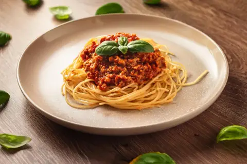 Pyszne spaghetti bolognese, idealne na prosty obiad. Aromatyczny sos mięsny z pomidorami i bazylią na złocistym makaronie.