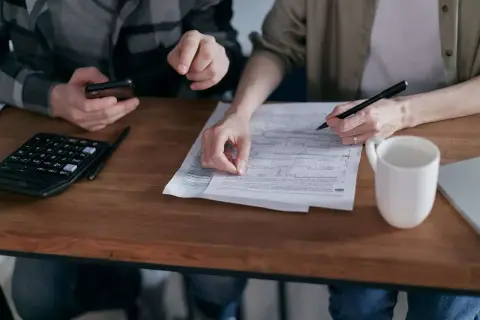 Para dowiedzieć się, jak zapłacić PCC-3 przez internet, analizuje dokumenty, używając kalkulatora i telefonu.
