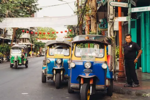 Tuk-tuks coloridos en una calle de Bangkok, perfectos para explorar la ciudad. ¡La mejor época para viajar a Tailandia es ahora!