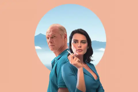 Para z filmu "La Gomera" na tle gór i nieba. Mężczyzna z siwymi włosami i kobieta z papierosem w dłoni.