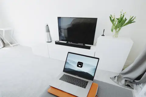 Laptop z ikoną AirPlay, gotowy do przesyłania obrazu na telewizor. To właśnie airplay co to - bezprzewodowe udostępnianie ekranu.