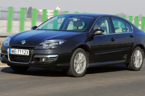 Czarny Renault Laguna 3 2.0 dCi w ruchu drogowym. Elegancki sedan z charakterystycznym przodem i felgami.