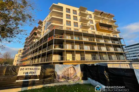 Budynek mieszkalny w budowie z balkonami i banerem "DO WYNAJĘCIA FOR RENT".