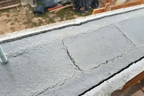 Betonowy wieniec budowlany z widocznymi pęknięciami, przygotowany do dalszych prac.