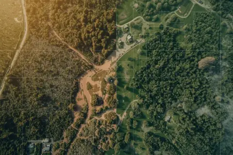 Ortofotomapa co to? Widok z lotu ptaka na las, rzekę i zabudowania. Siatka kwadratów sugeruje precyzyjne pomiary.