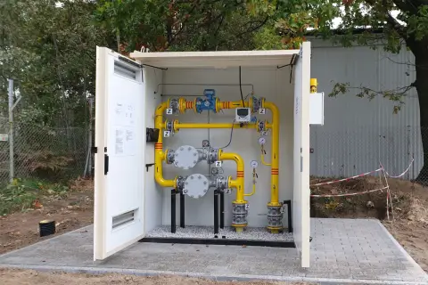 Nowe instalacje gazowe w Górze Kalwarii. Żółte rury, zawory i manometry w obudowie.