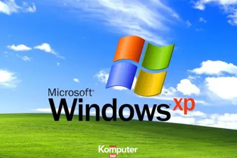 Ikoniczny krajobraz z zielonym wzgórzem i błękitnym niebem z chmurami, z logo Microsoft Windows XP.