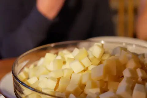Un bol rempli de dés de fromage savoyard, prêt à être fondu pour un plat réconfortant.