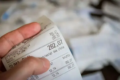 Dłoń trzyma rachunek za paliwo. Suma to 282,07 zł. Czy to będzie zwrot bez paragonu?