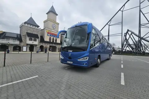 Niebieski autokar przed zamkiem w Energylandii, gotowy na wycieczkę z Wrocławia.