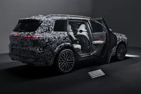 Nowy Audi Q9 w kamuflażu, z otwartymi drzwiami, prezentuje luksusowe wnętrze. Czekamy na jego cenę i premierę!