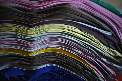 Pile de feuilles de cuir pleine fleur aux couleurs vives, formant des vagues douces.