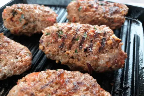 Soczyste Adana kebab w trakcie grillowania. Idealny przepis na pyszny obiad.