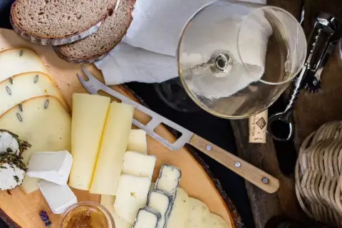 Deska serów z chlebem i kieliszkiem wina, idealna do degustacji Bardolino Chiaretto.