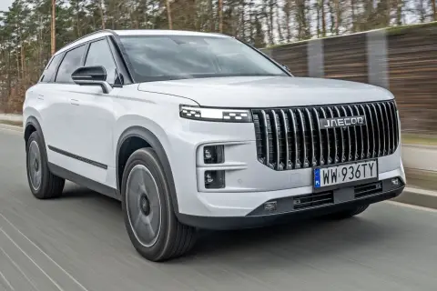 Biały Jaecoo 7 w ruchu, z charakterystycznym grillem i światłami LED. Sprawdź jego atrakcyjną jaecoo 7 cenę!