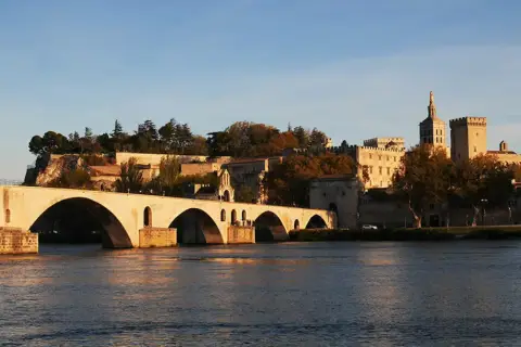 Słynny most Saint-Bénézet i Pałac Papieski w Awinionie, piękne miasto nad Rodanem, w blasku zachodzącego słońca.