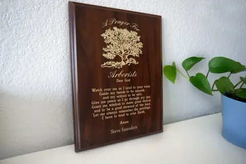 Drewniana tablica z modlitwą dla arborysty, ozdobiona drzewem.