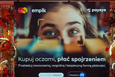 Reklama Empiku z hasłem "Kupuj oczami, płać spojrzeniem". Pokazuje zbliżenie na zielone oczy młodej kobiety, sugerując innowacyjne metody płatności Payeye.