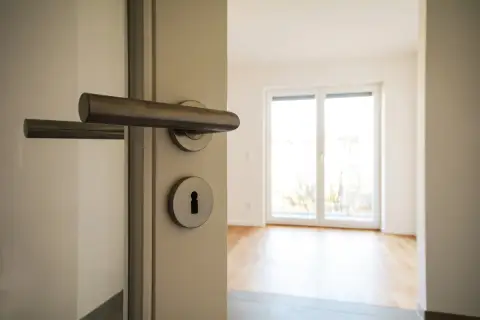 Otwarcie drzwi do pustego mieszkania. Zastanawiasz się, ile kosztuje kawalerka w Niemczech?