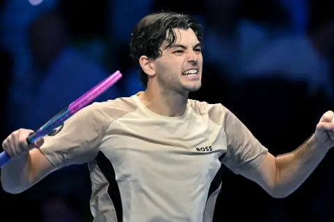 Taylor Fritz, tenisista, triumfuje po wygranym punkcie, zaciskając pięść i unosząc rakietę.