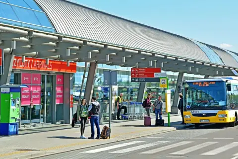 Autobus z napisem "Stacja Modlin" czeka na pasażerów. To dobry sposób, jak dojechać na lotnisko Modlin.