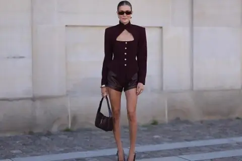 Mujer con blazer y shorts de cuero en tono burdeos, demostrando cómo combinar color burdeos mujer con estilo.