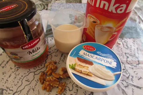 Składniki na kawę Inka z mlekiem: słoik miodu, kubek mleka, opakowanie serka mascarpone, orzechy włoskie i puszka kawy Inka.