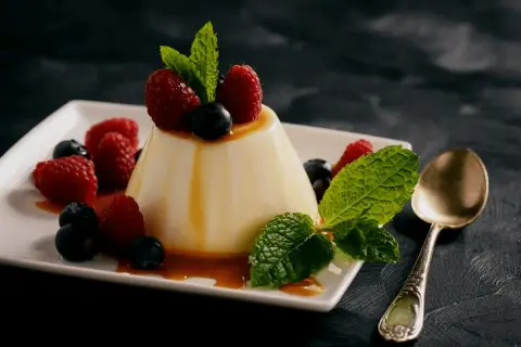 Panna cotta z malinami i borówkami, polana syropem. Idealny deser, gdy szukasz prostego panna cotta przepis.