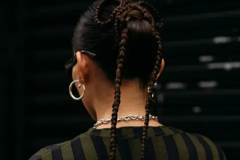 Peinados para conciertos: trenzas recogidas en forma de moño con dos coletas largas.
