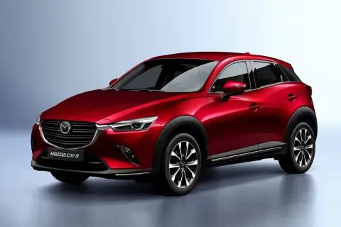 Czerwona Mazda CX-3 na tle jasnoszarego tła. Stylowy crossover, który zbiera pozytywne mazda cx-3 opinie.