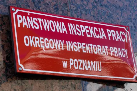 Tablica Państwowej Inspekcji Pracy w Poznaniu. To tutaj nadzór i kontrolę nad przestrzeganiem prawa pracy sprawuje instytucja dbająca o bezpieczeństwo pracowników.