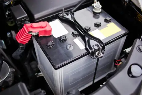 Akumulator w komorze silnika Renault Espace 4. Czerwona osłona na biegunie dodatnim.