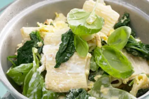 Herzhafte Spinat Ricotta Tortellini mit frischem Spinat und cremiger Sauce in einer Schüssel.
