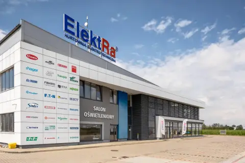 Nowoczesny budynek hurtowni z art elektrotechnicznymi Elektra Śrem. Na fasadzie widoczne liczne logotypy znanych marek.