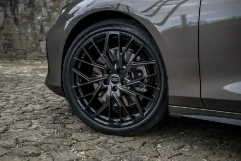 Błyszczące, czarne felgi Audi z homologacją opon Michelin Pilot Sport 5 na kamiennej nawierzchni.