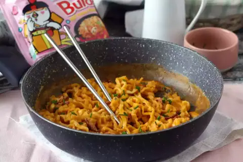Pikantny buldak carbonara w kremowym sosie, gotowy do jedzenia.