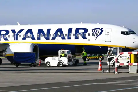 Samolot Ryanair na płycie lotniska. Zastanawiasz się, ile wcześnie można się odprawić w Ryanair?