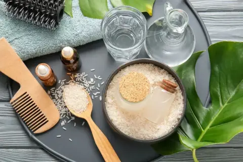 Ingredientes para un tratamiento capilar: arroz, agua de arroz, aceites y peine.