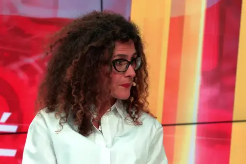 Aleksandra Pawlicka, z burzą kręconych włosów i okularami, opowiada o swoich dzieciach na tle kolorowego studia.