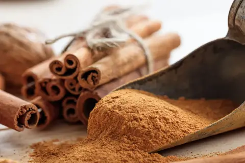 Zimtstangen und gemahlener Zimt in einer Schaufel. Zimt gesund und aromatisch, perfekt für die Küche.