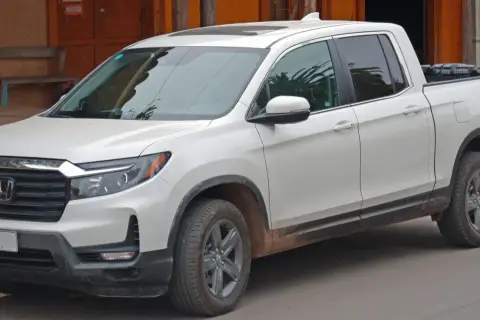 Biały Honda Ridgeline z błotem na progach, gotowy na przygodę.