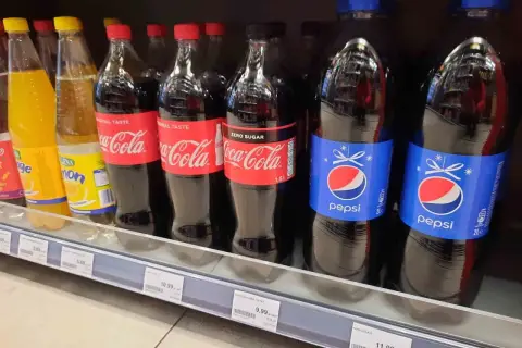 Butelki Pepsi i Coca-Coli na półce sklepowej. Cena Pepsi 2L to 11,99 zł.